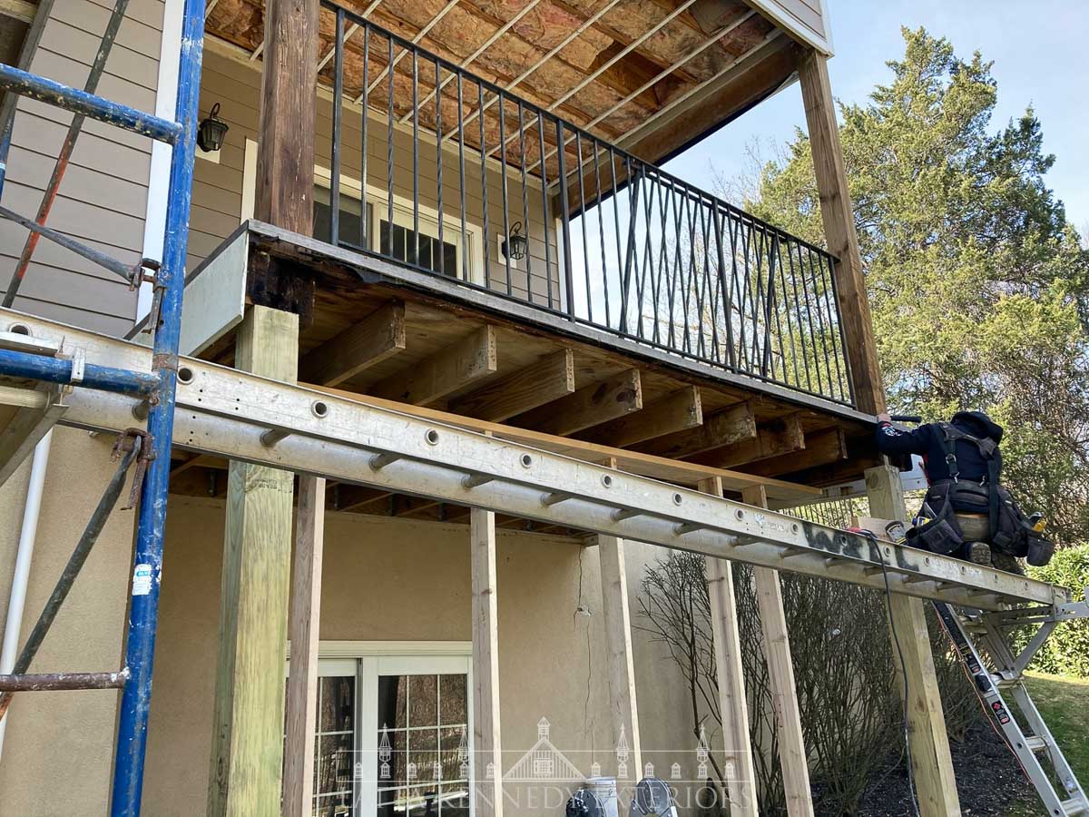 A temporary wall was built, the deck was secured with bottle jacks and support posts were carefully removed and replaced with Pressure Treated Lumber. 