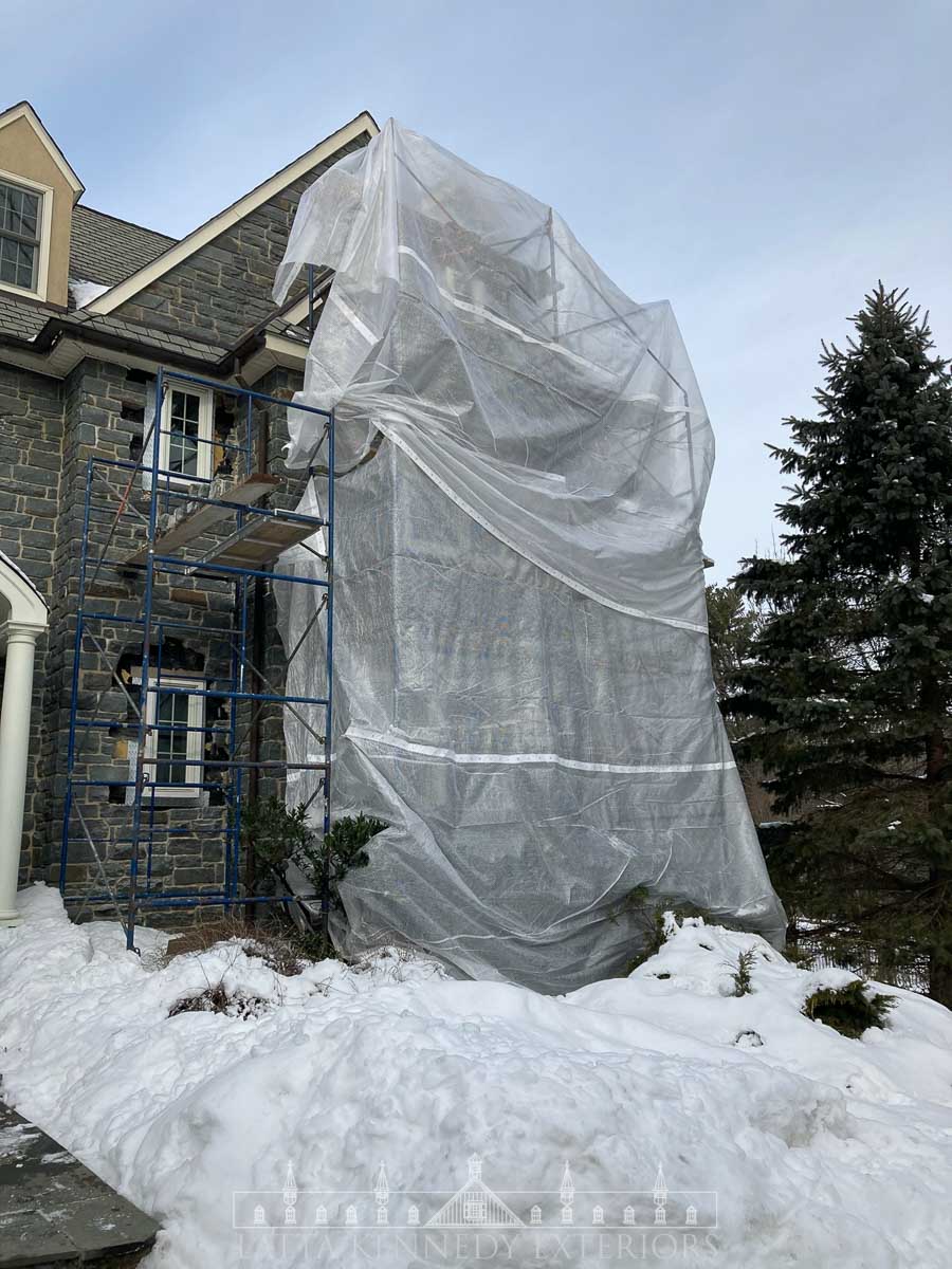 As this project was started in the winter, we had to get creative and assure the mortar could properly dry and adhere. Because of this, we wrapped our scaffolding with 6 ml plastic and pumped the enclosure, using an industrial heater. This enclosed, heated scaffolding allowed us to continue masonry work through the cold temperatures and even snow. 