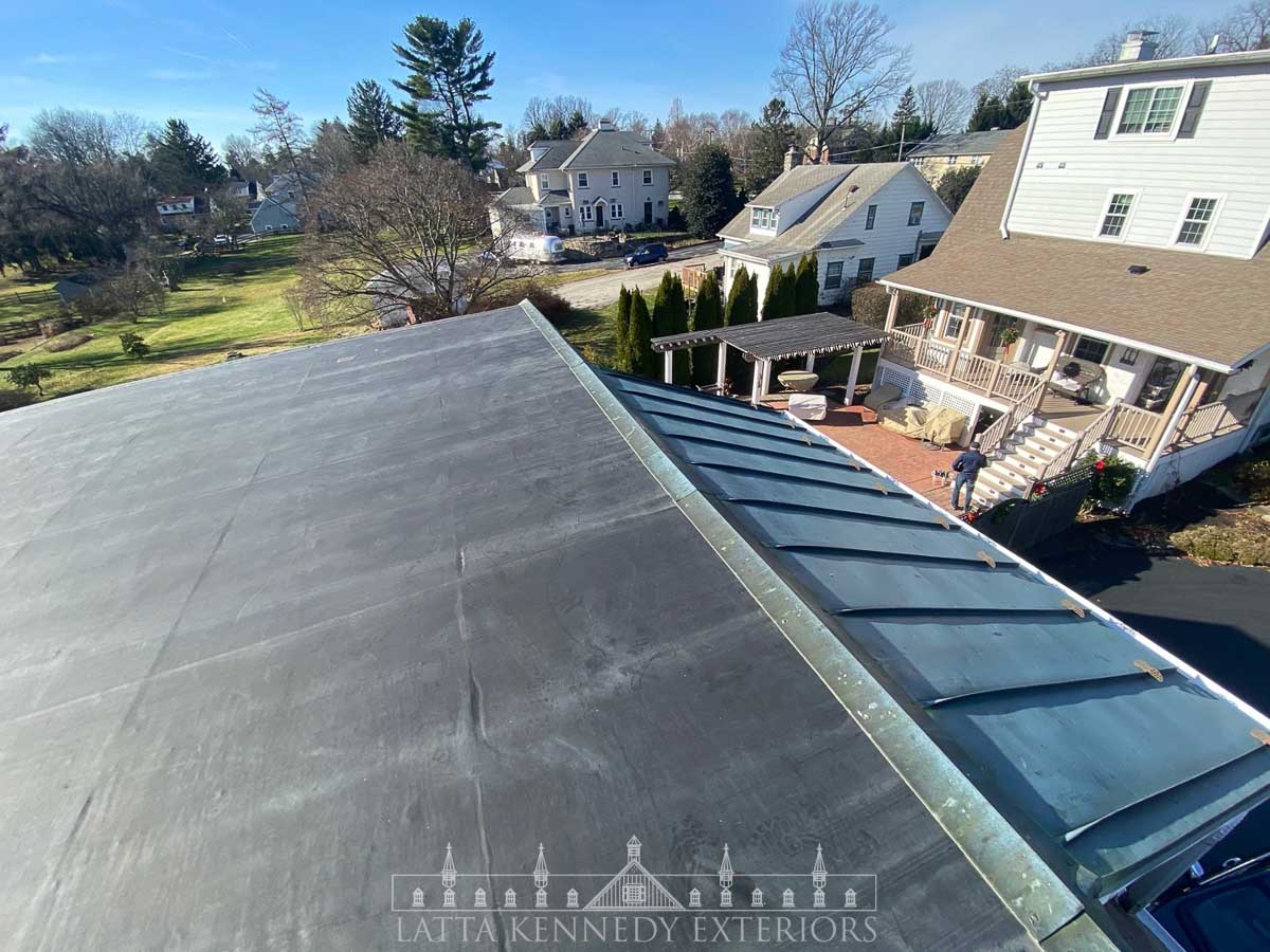 Residential roof repair project on an existing flat roof and copper pent with flashing details.