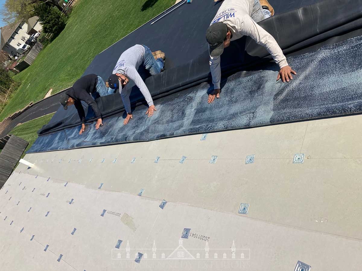 Carefully adhering the new EPDM rubber roofing to the insulation.